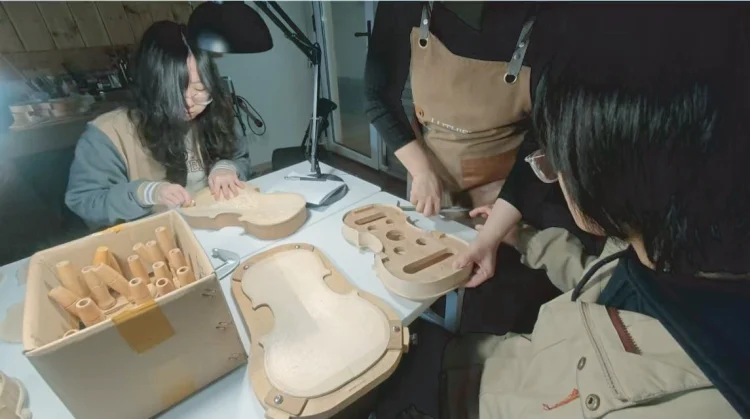 Students sand and shape violin plates